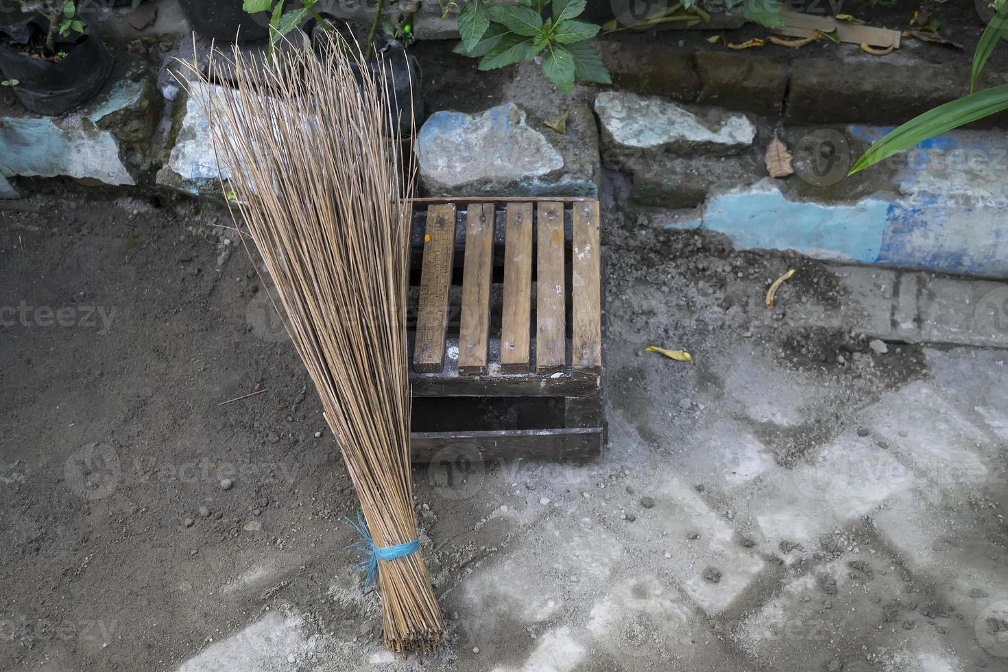 Broom sticks and a small seat made of bamboo with a road photo