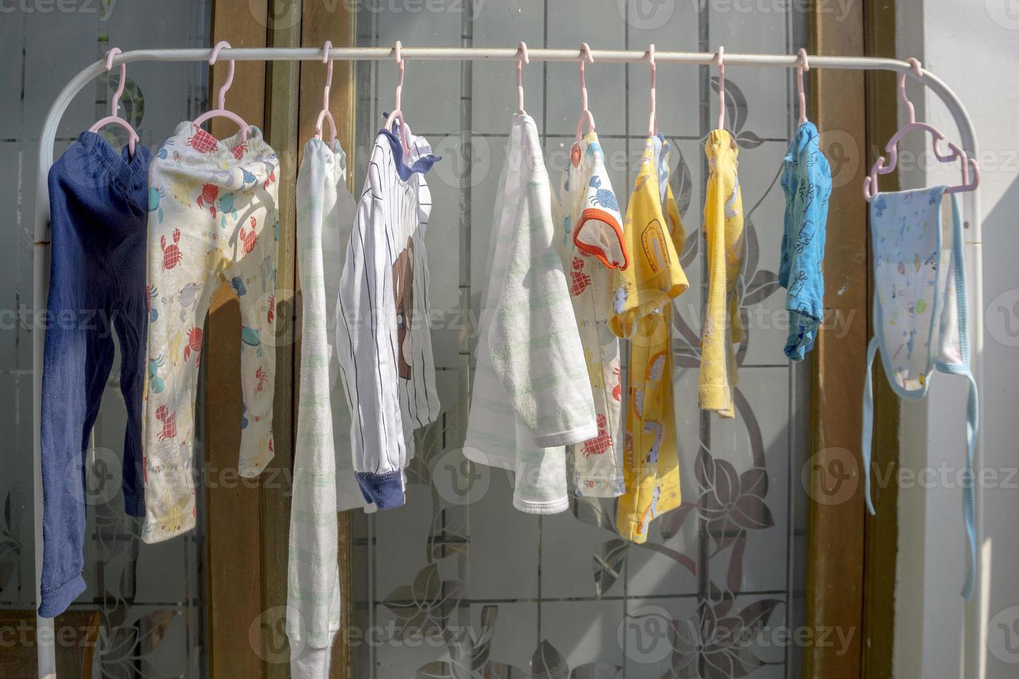 Drying baby clothes by hanging in front of the house. photo
