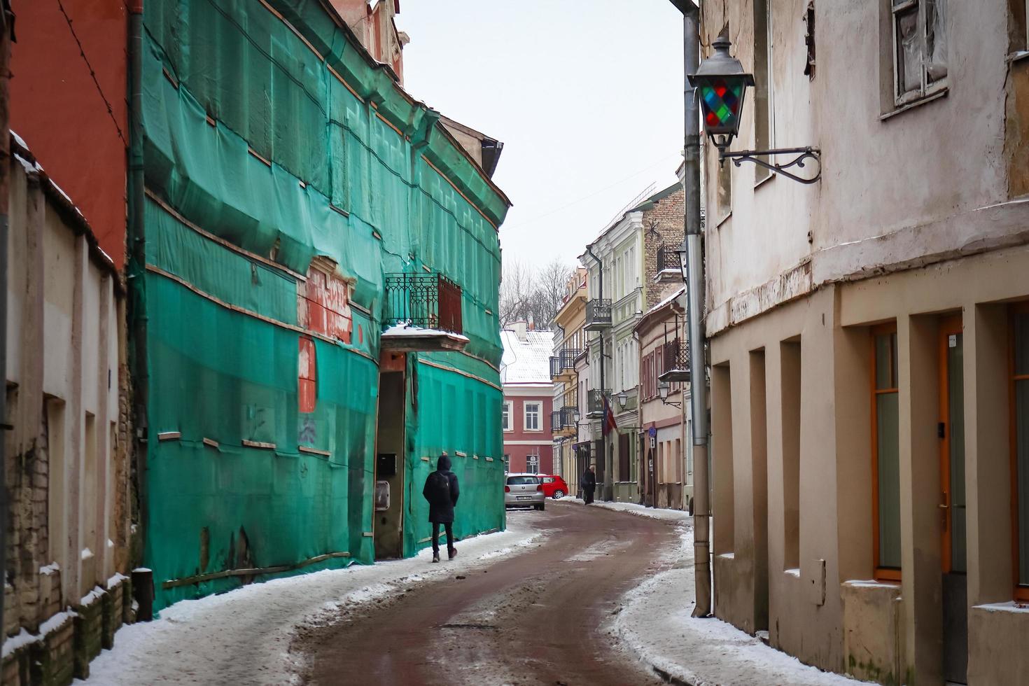 Jewish Quarter, Vilnius, Lithuania - December, 2021 Vilnius Old Town Jewesh Ghetto Part in winter snow with green net covering old building photo