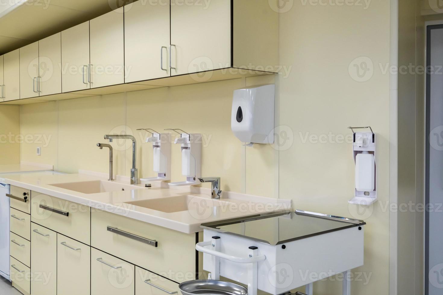 elbow soap and antiseptic dispenser or sanitizer wall mounted for hand disinfection and water tap sink with faucet bathroom or clinic photo