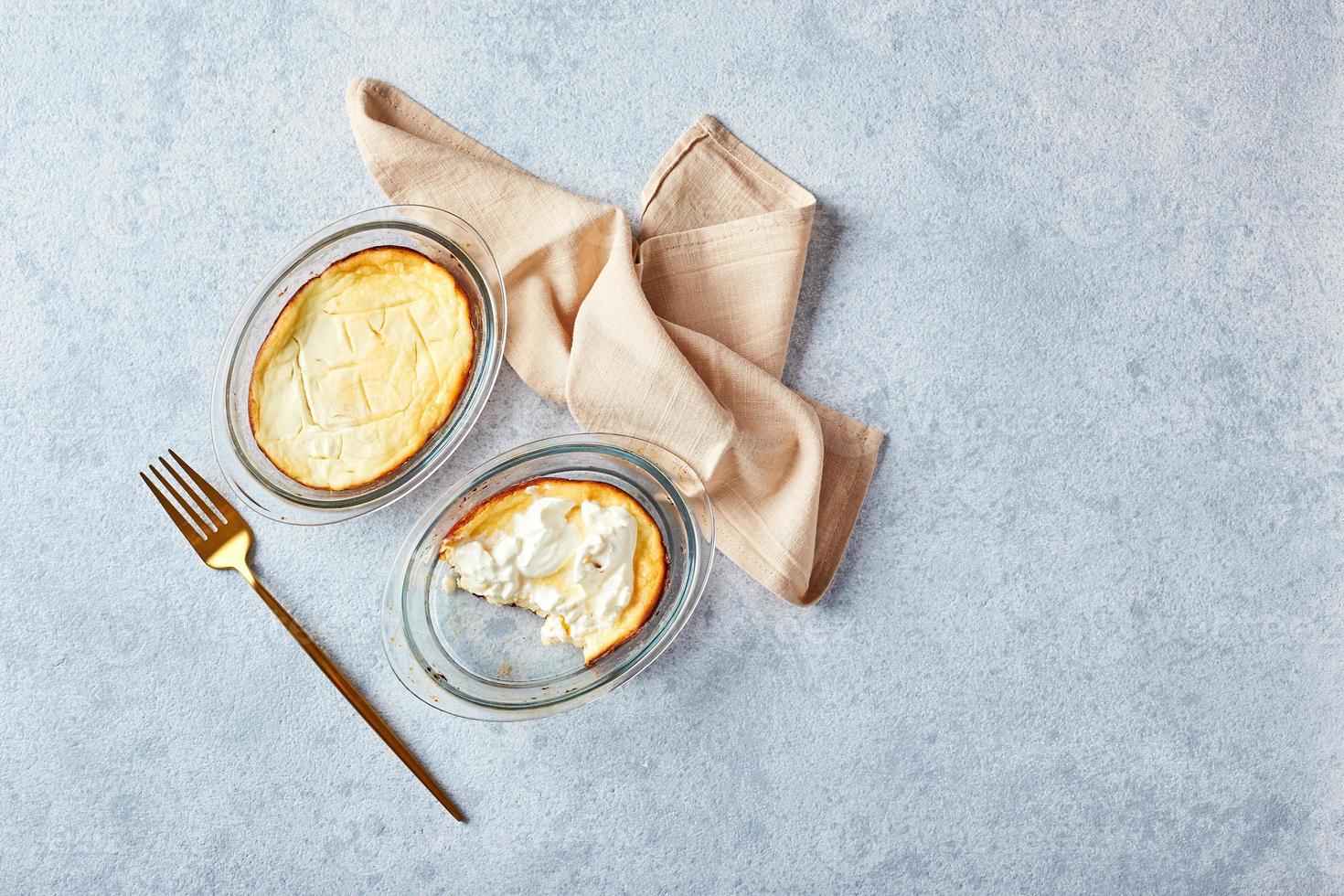 Delicious cottage cheese casserole in portioned glass forms with sour cream. Traditional Russian cuisine for breakfast - Zapekanka photo