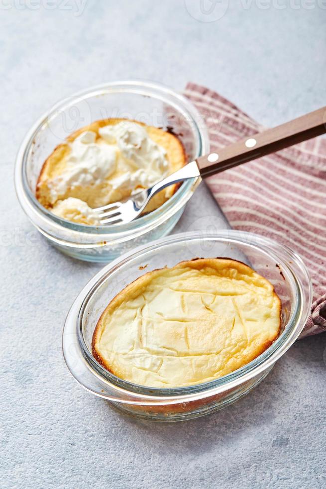 Delicious cottage cheese casserole in portioned glass forms with sour cream. Traditional Russian cuisine for breakfast - Zapekanka photo