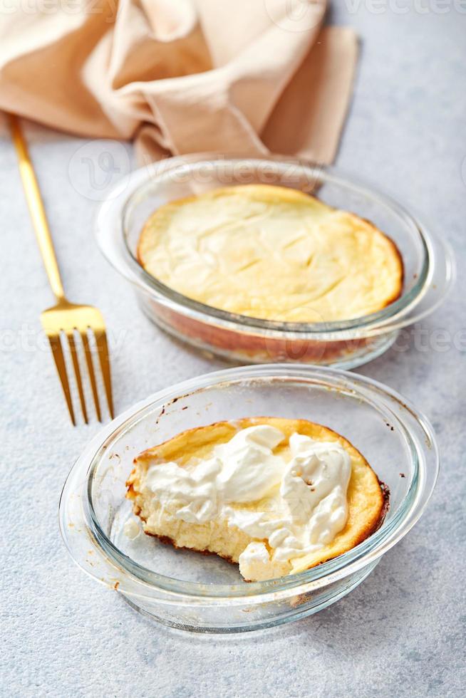 Delicious cottage cheese casserole in portioned glass forms with sour cream. Traditional Russian cuisine for breakfast - Zapekanka photo