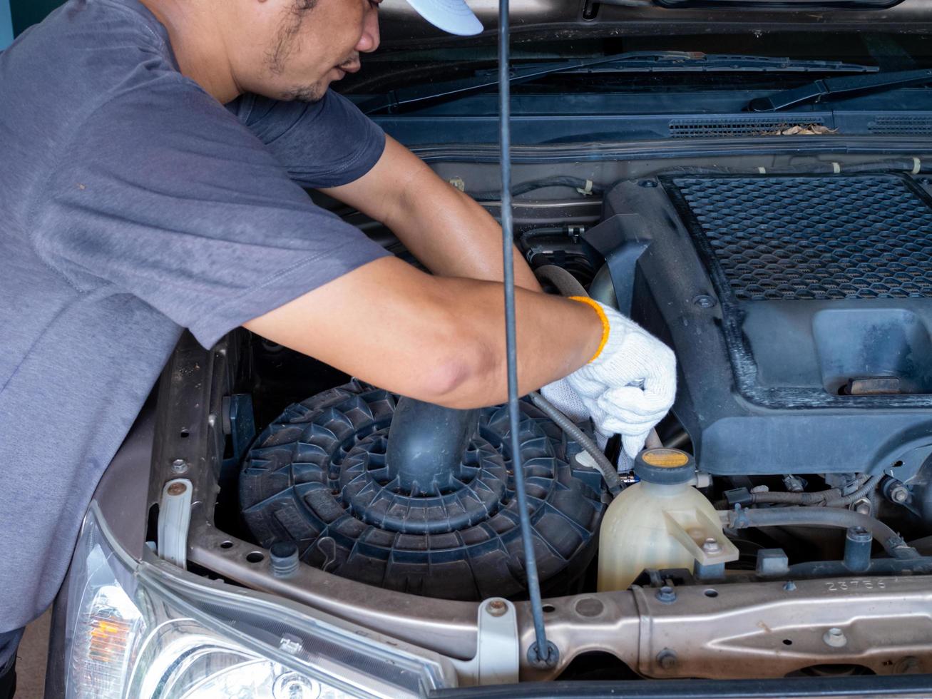 Mechanic holding a block wrench handle while fixing a car. photo