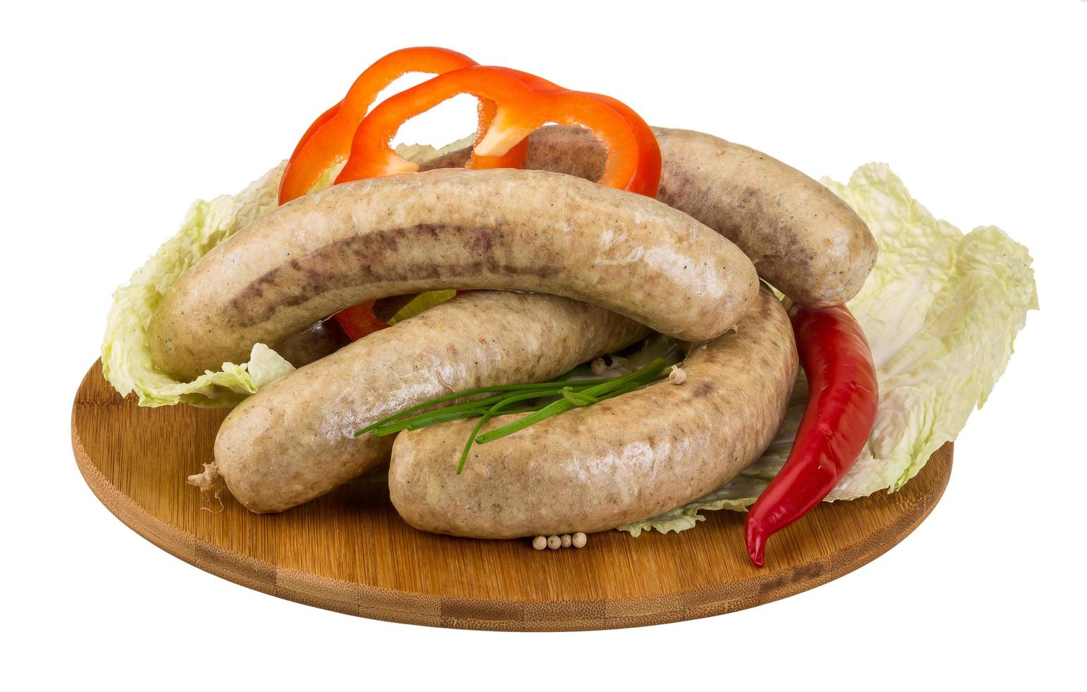 Grilled sausages on wooden board and white background photo