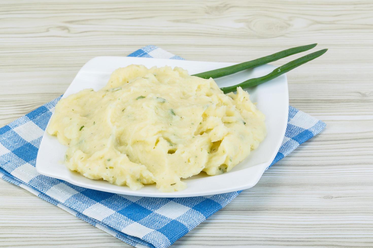 Mash potato on the plate and wooden background photo
