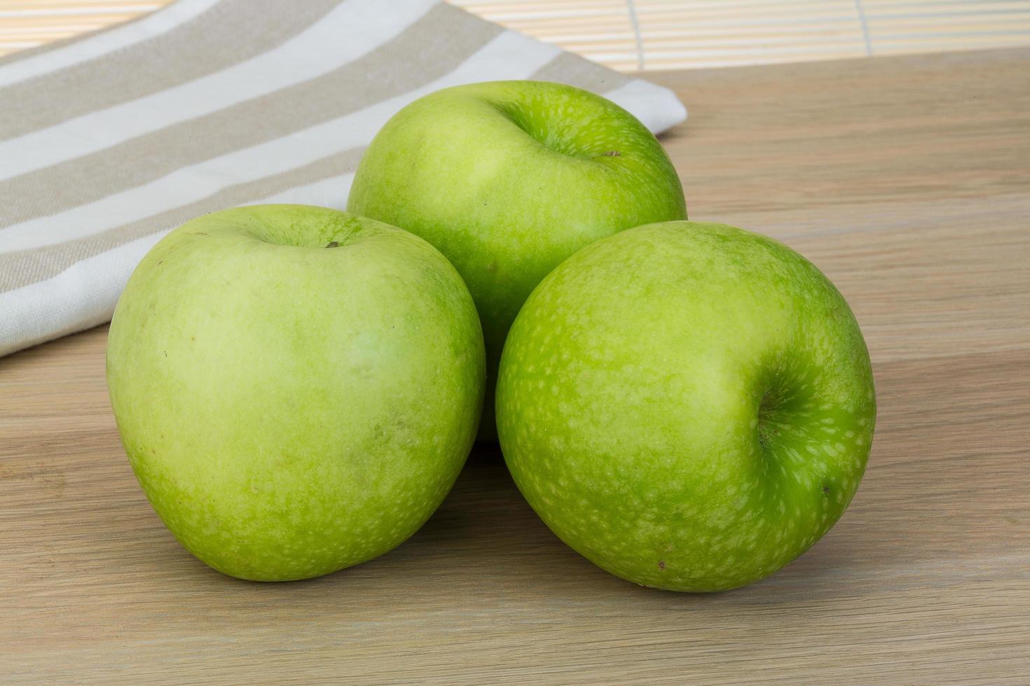 Green apple on wooden background photo