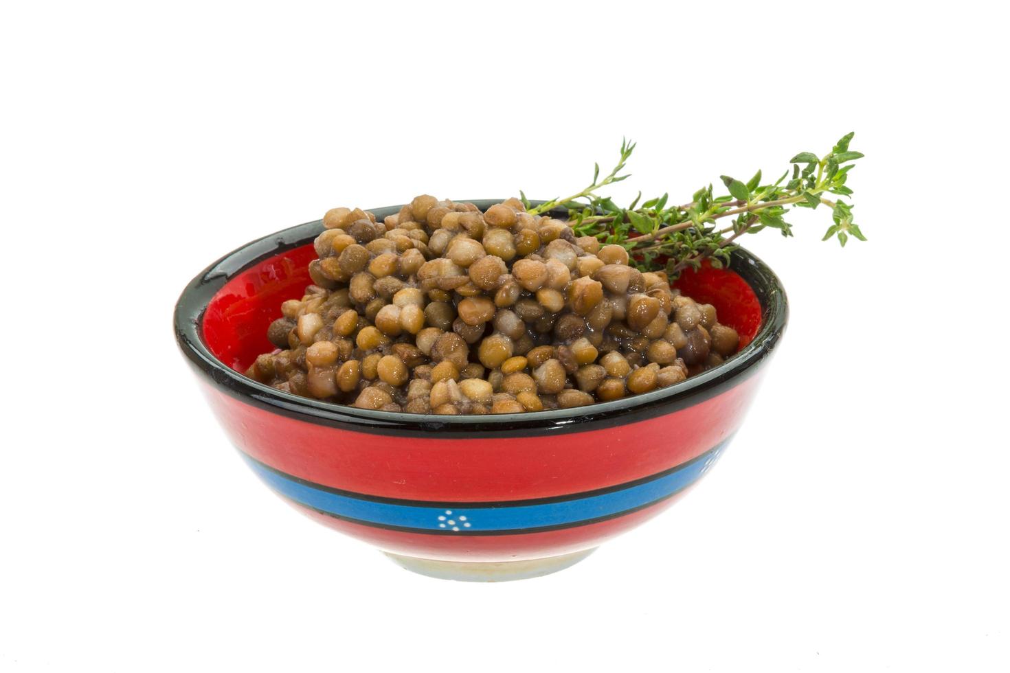 Backed lentils in a bowl on white background photo