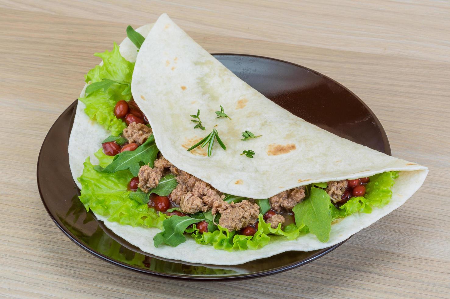 burrito en el plato y fondo de madera foto