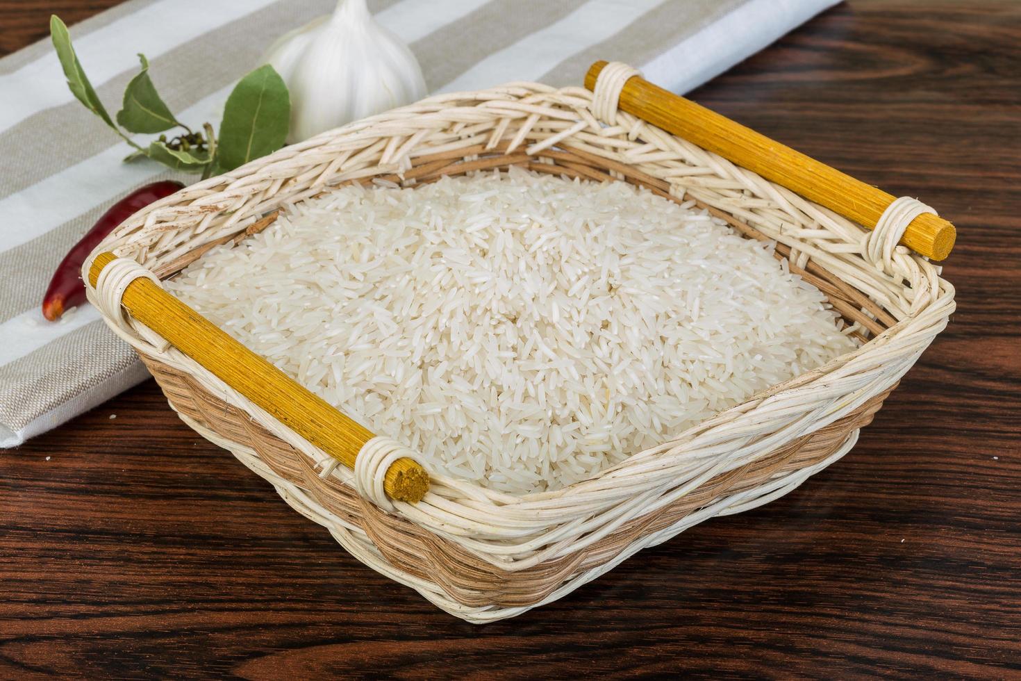 Basmati rice in a basket on wooden background photo