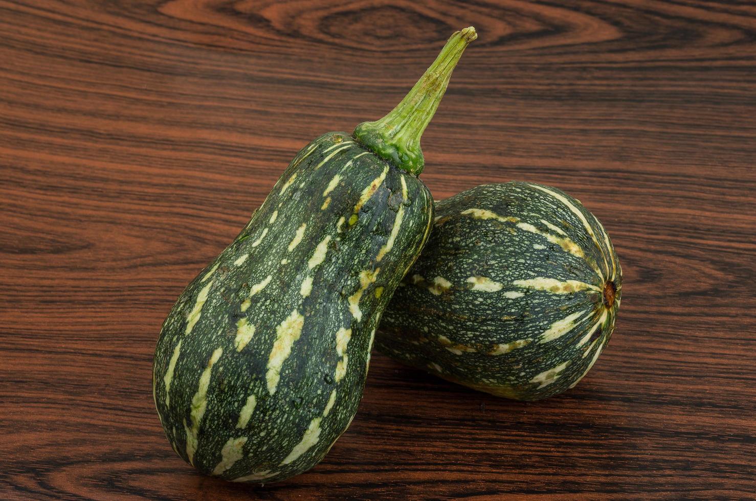 Green pumpkin on wooden background photo