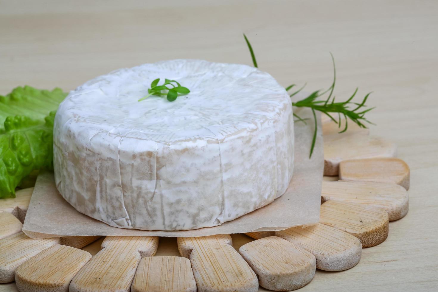 Camembert cheese on wooden board and wooden background photo