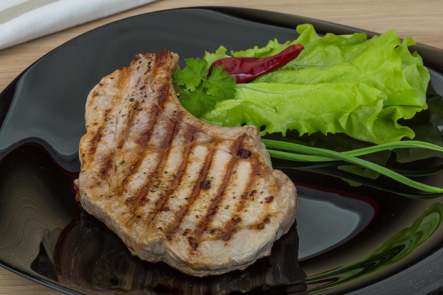 Grilled t-bone steak on the plate and wooden background photo