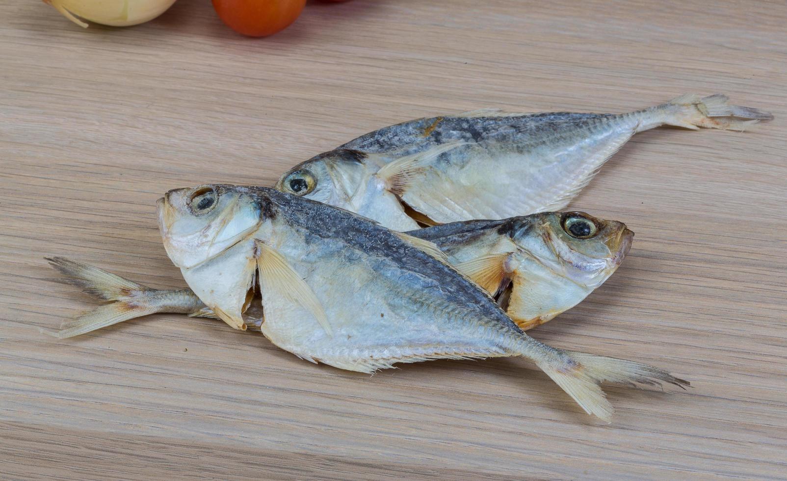 Dry fish on wooden background photo