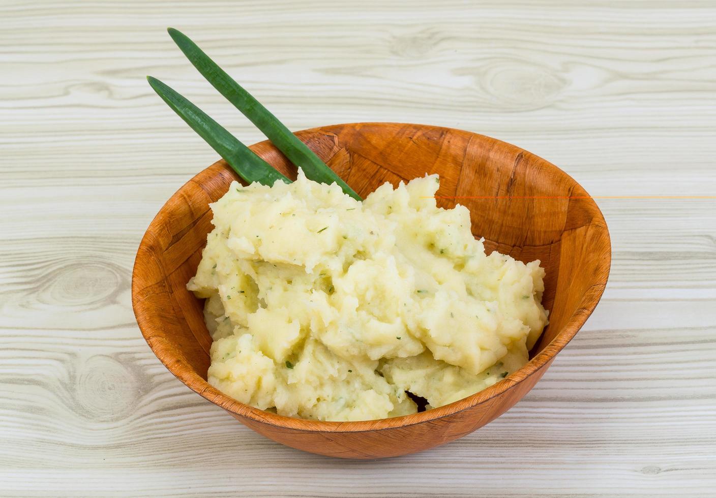 puré de patata en un bol sobre fondo de madera foto