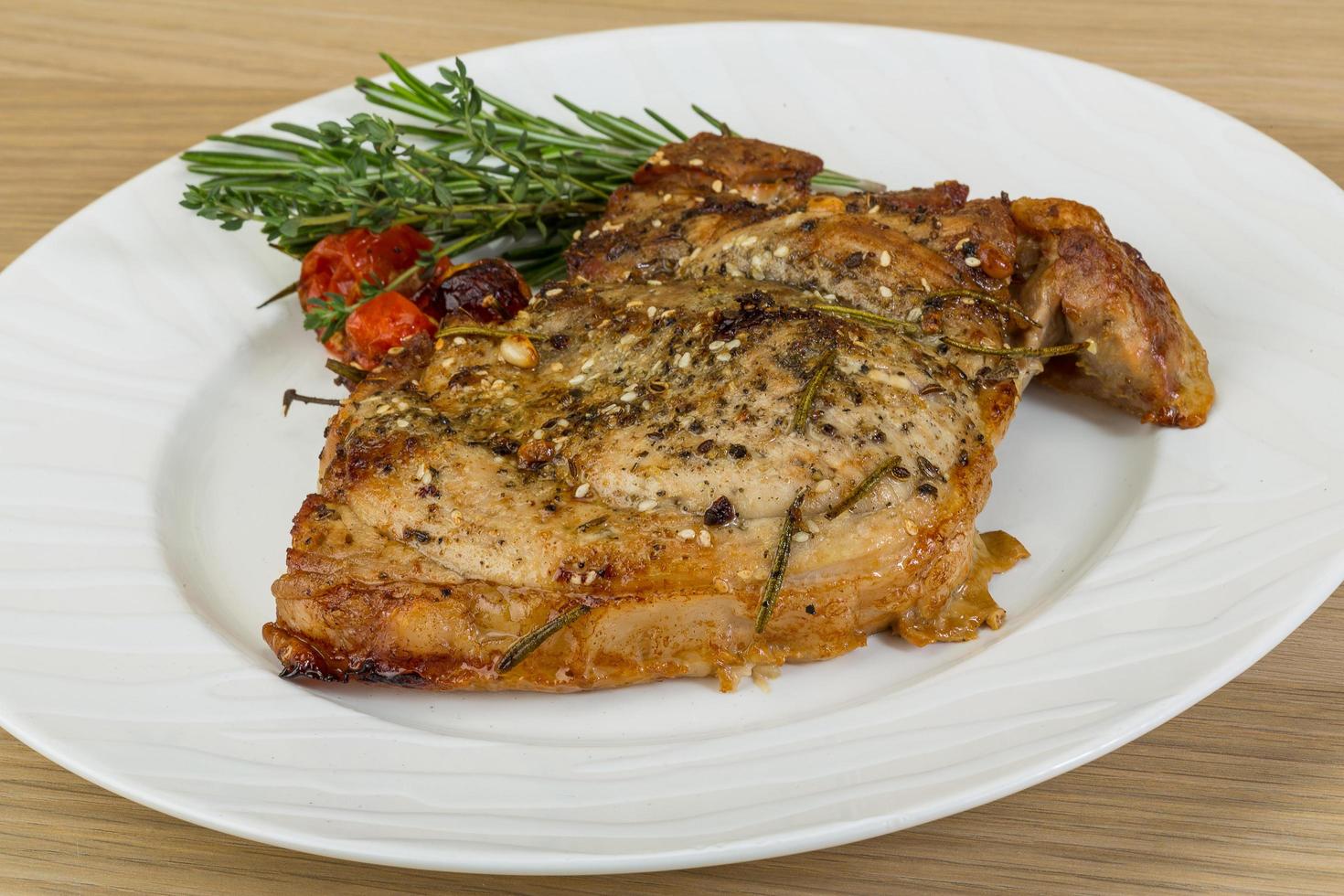 Roasted pork on the plate and wooden background photo