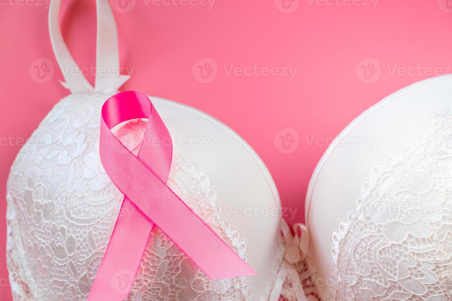 mes de la conciencia del cáncer de mama. sujetador de mujer y cinta rosa sobre fondo brillante. concepto de atención médica, diagnóstico oncológico. foto
