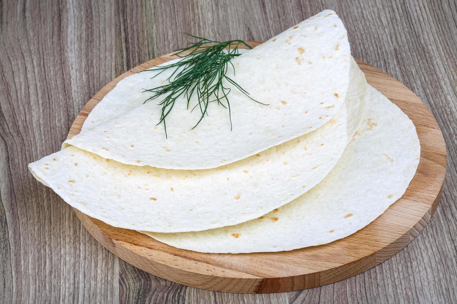 Tortillas on wooden board and wooden background photo