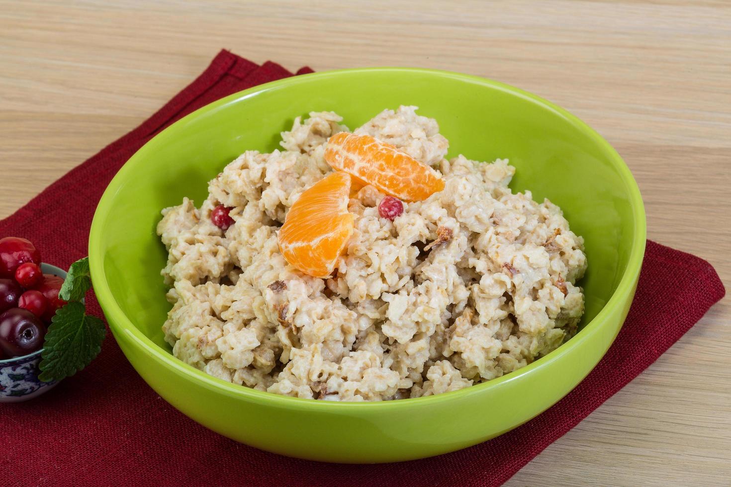 Oatmeal in a bowl on wooden background photo