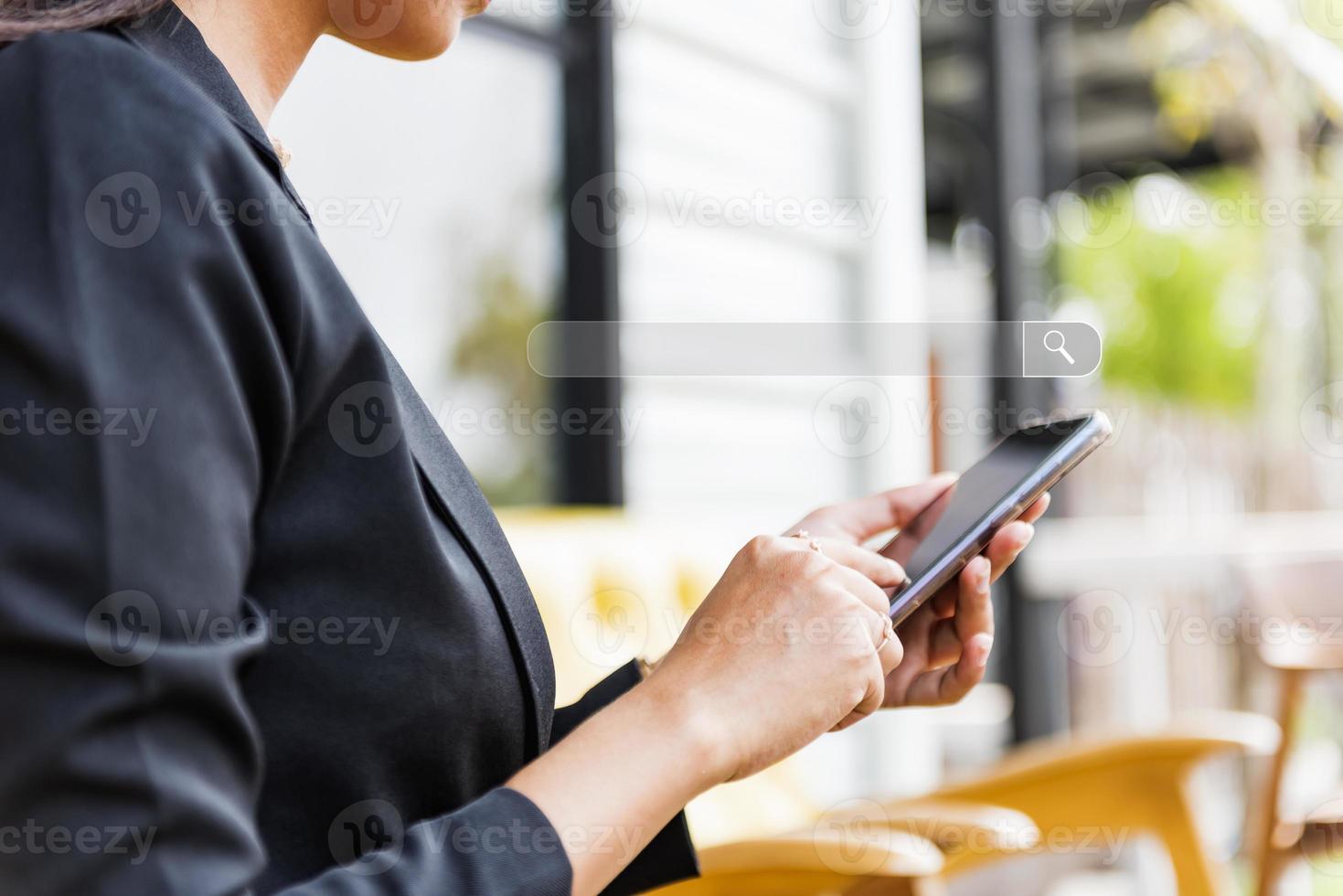 A businesswoman touches the screen of a mobile phone and a search page on the touch screen of a smartphone. photo