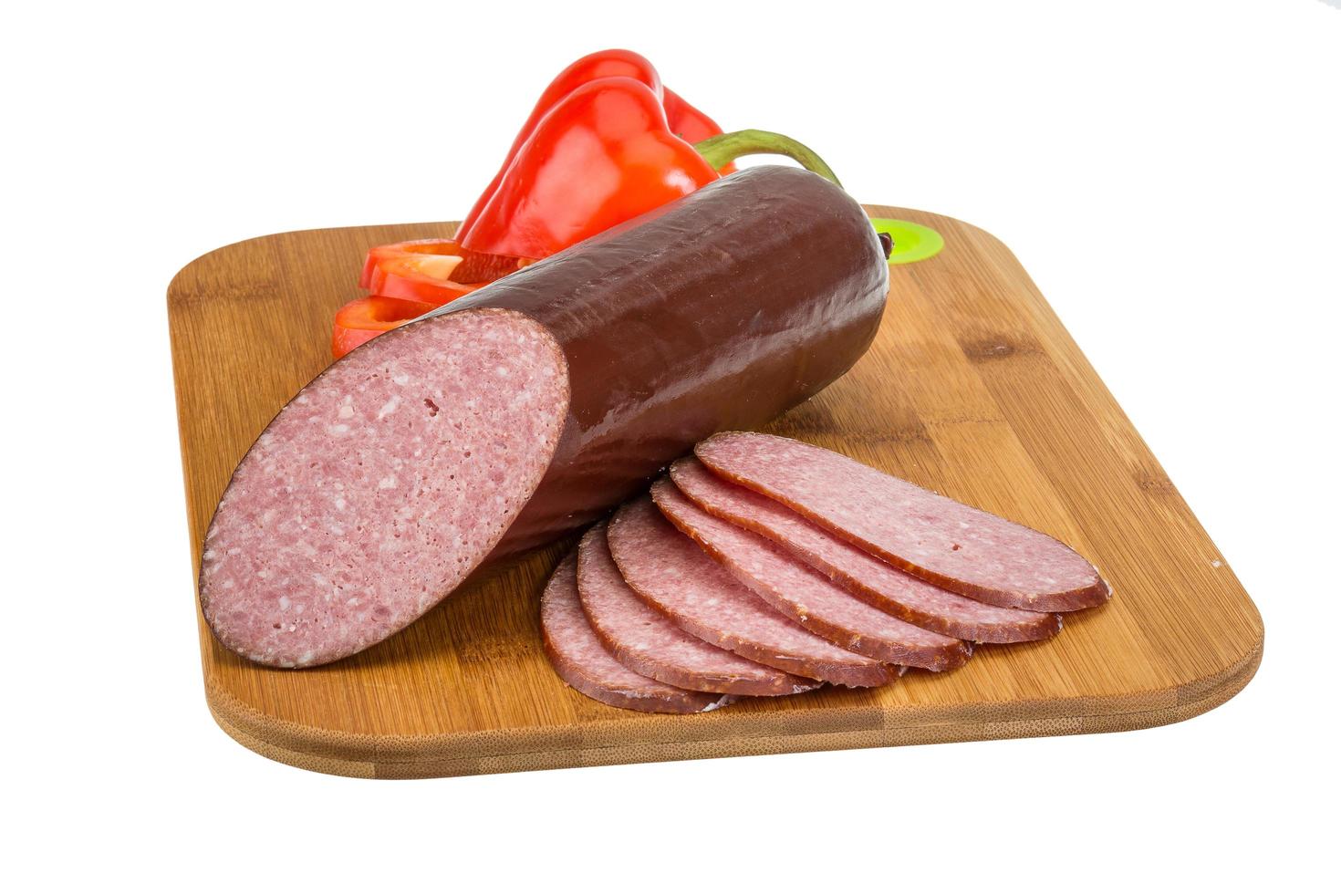 Sausages on wooden board and white background photo