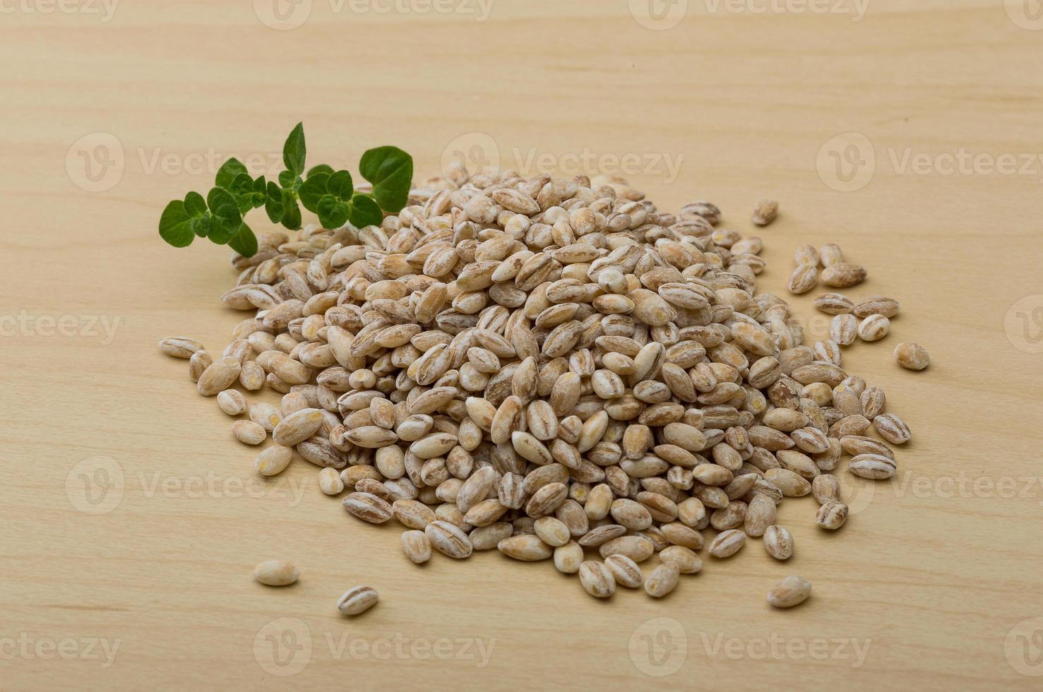 Pearl barley on wooden background photo