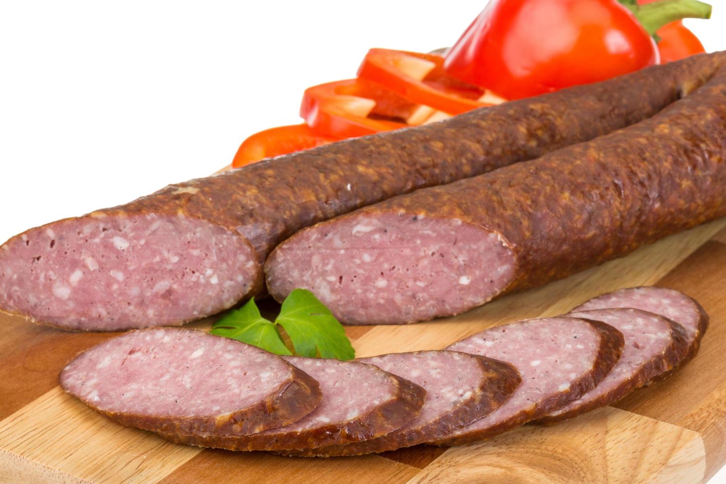 Sausages on wooden board and white background photo