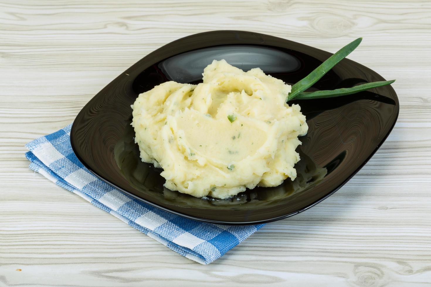 Mash potato on the plate and wooden background photo