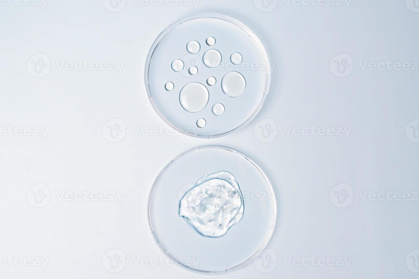 Transparent drops of cosmetic product serum gel in petri dish. Liquid texture with bubbles on blue background. Skincare products, natural cosmetic. Beauty concept for face and body care photo
