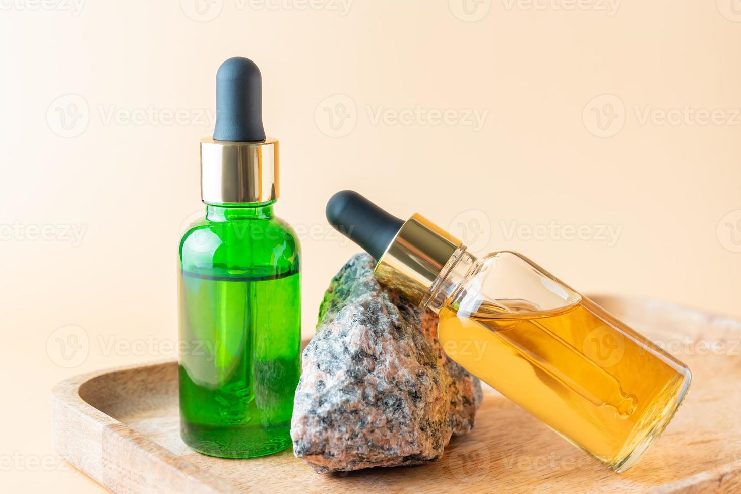 Aesthetic minimalist beauty care therapy concept. Organic serum oil cosmetics bottles on stone against beige background. Body, skin, face treatment product composition photo