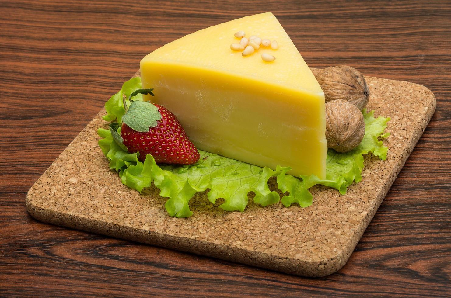 Parmesan cheese on wooden board and wooden background photo