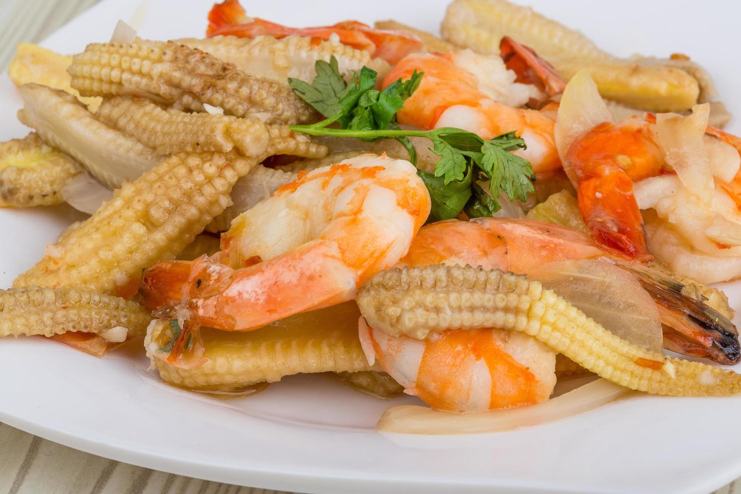 Shrimp and corn salad on the plate and wooden background photo