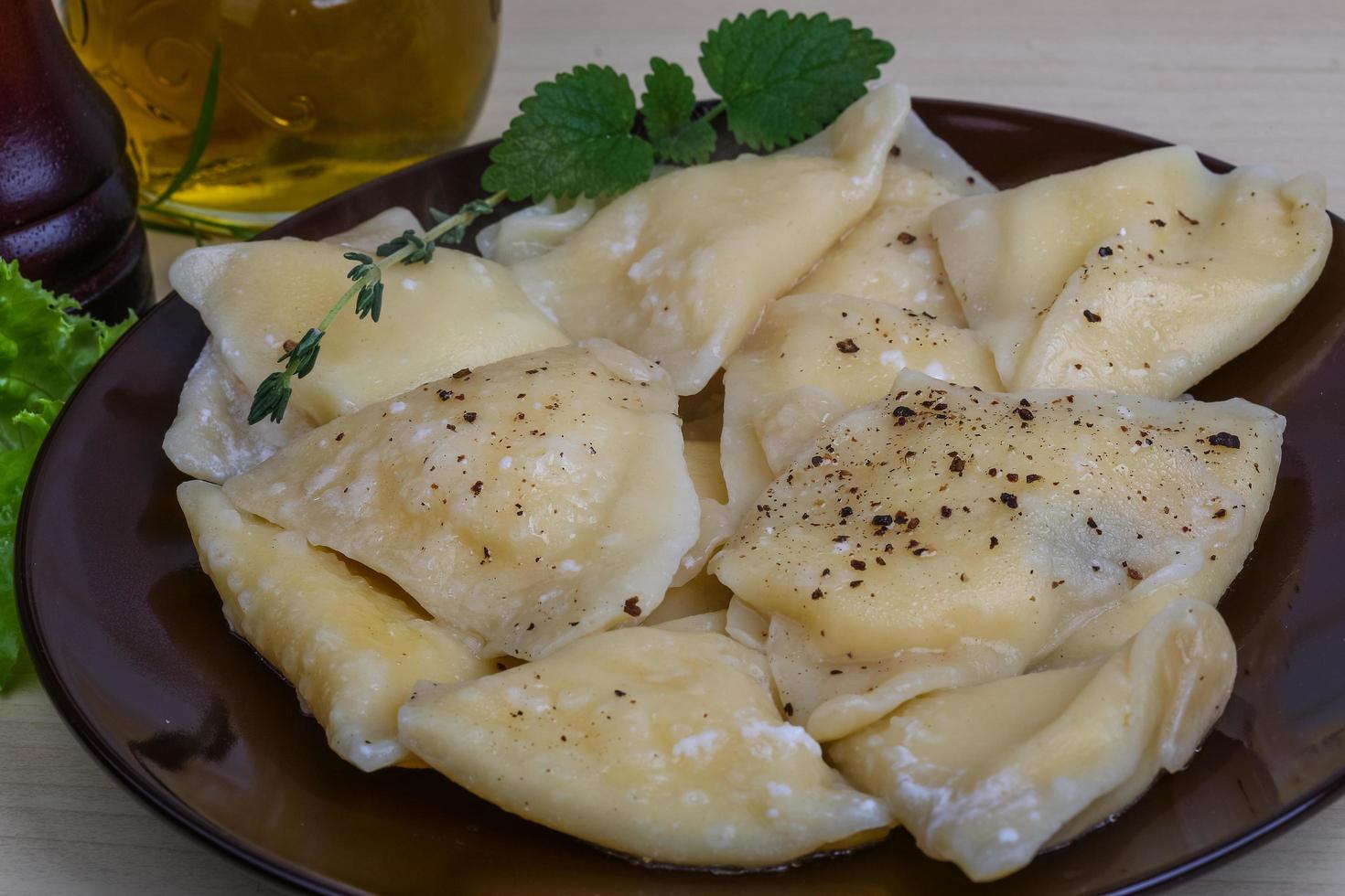 Vareniki on the plate and wooden background photo