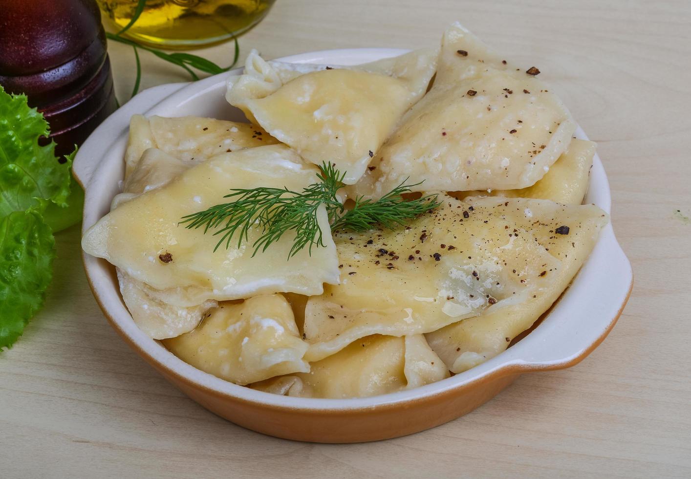 Vareniki in a bowl on wooden background photo