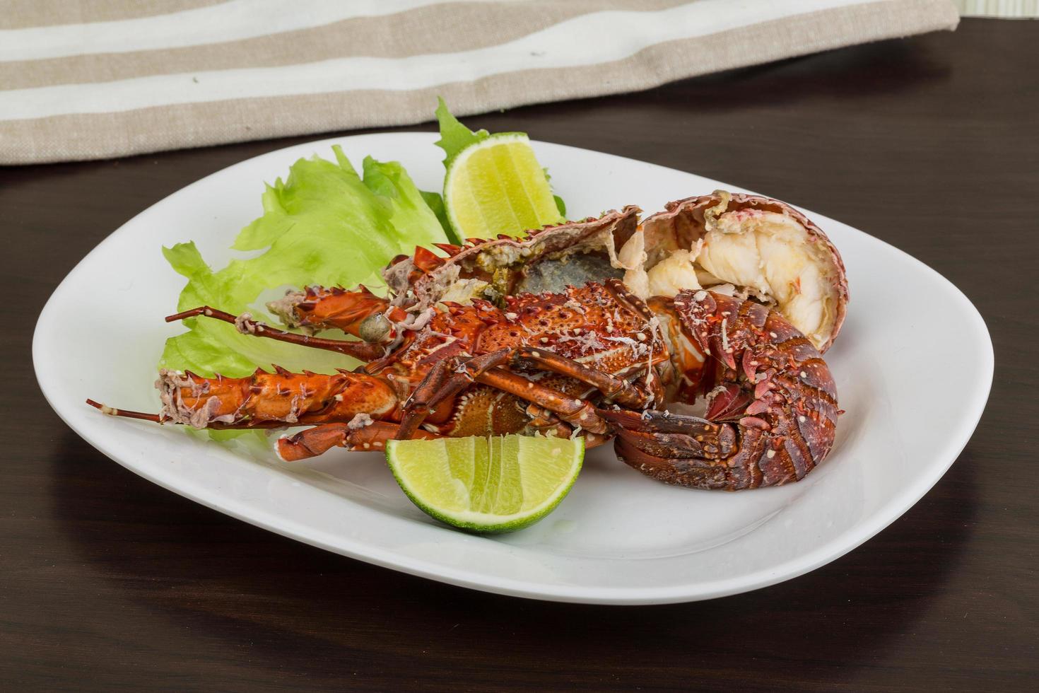 Spiny lobster on the plate and wooden background photo