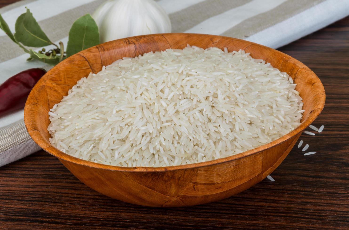 Basmati rice in a bowl on wooden background photo