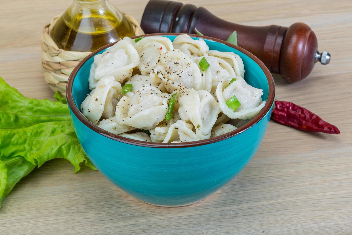 Boiled russian dumplings in a bowl on wooden background photo
