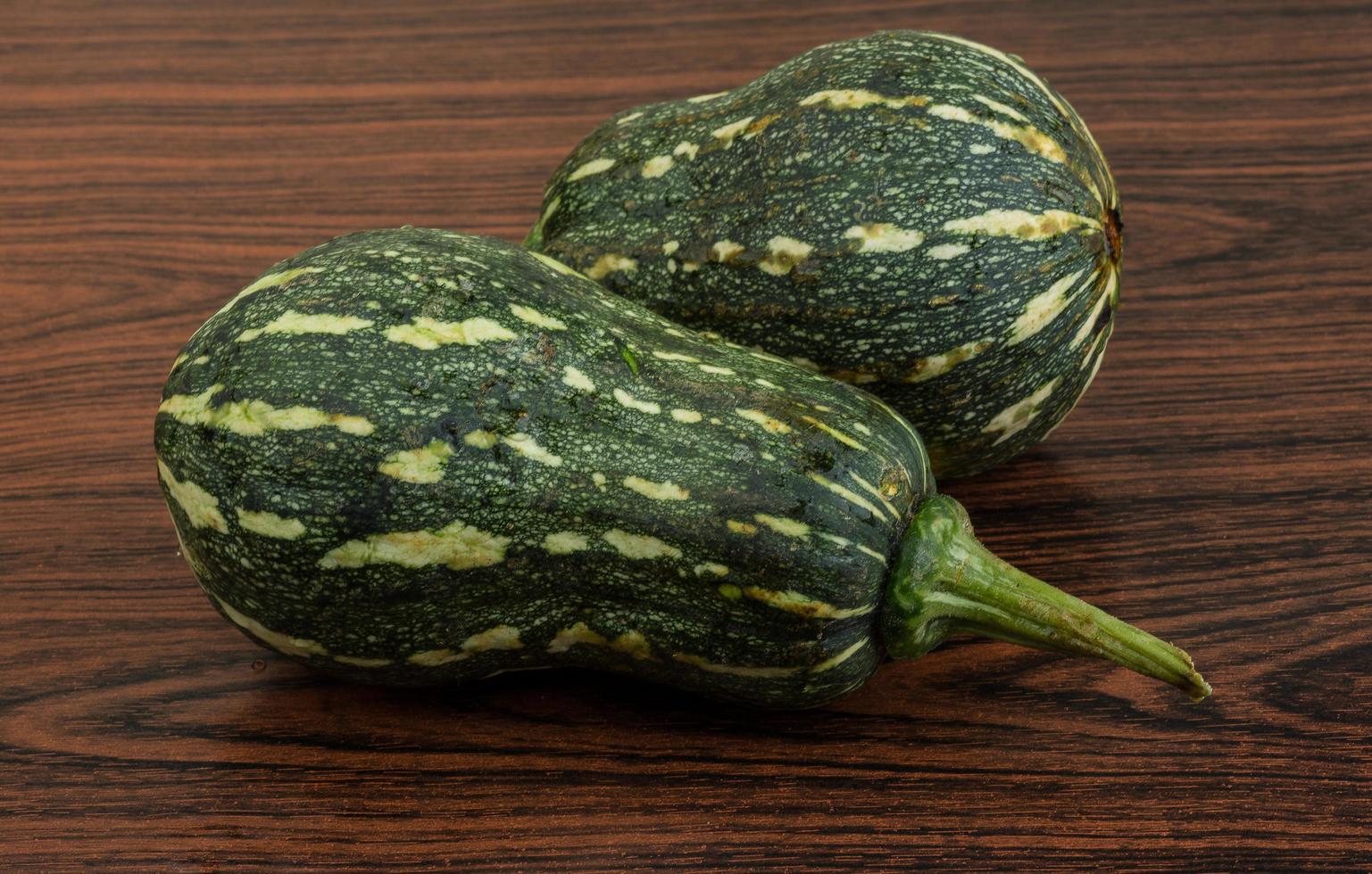 Green pumpkin on wooden background photo