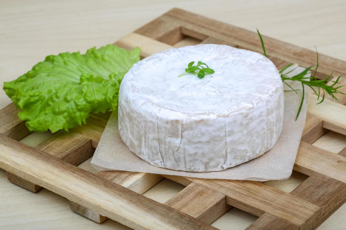 Camembert cheese on wooden board and wooden background photo