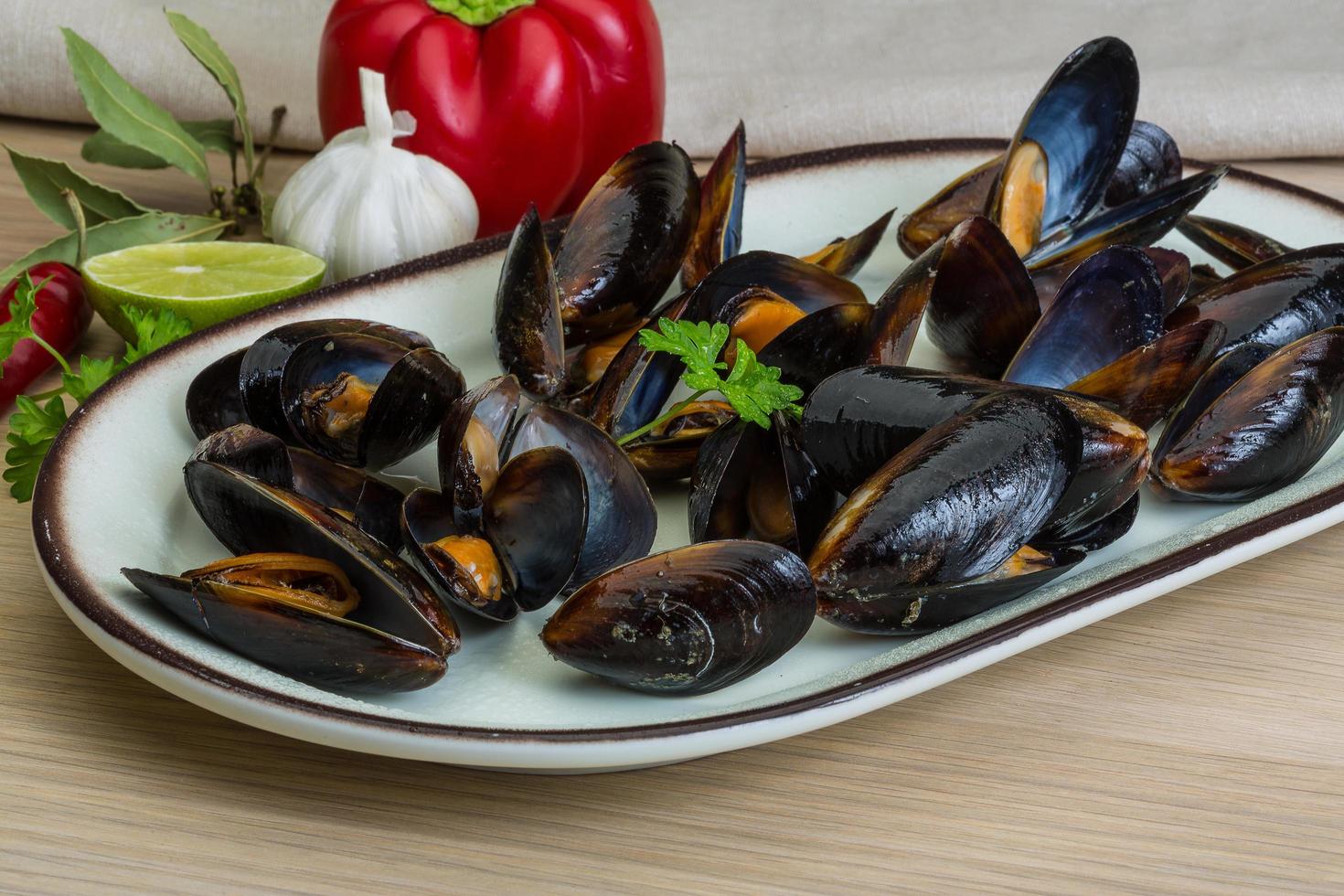 Mussels on the plate and wooden background photo