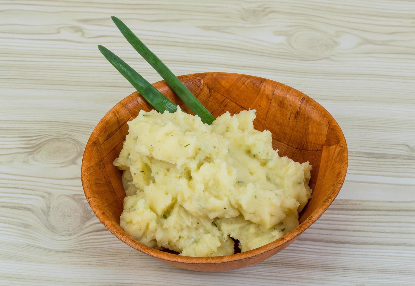 puré de patata en un bol sobre fondo de madera foto