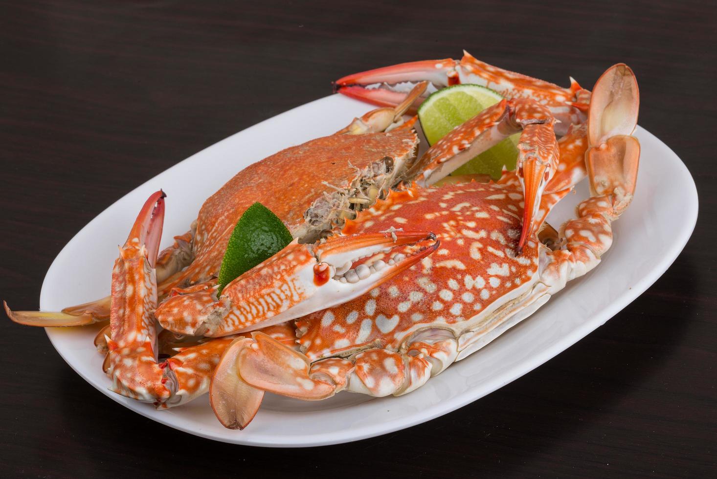 Boiled crabs on the plate and black background photo