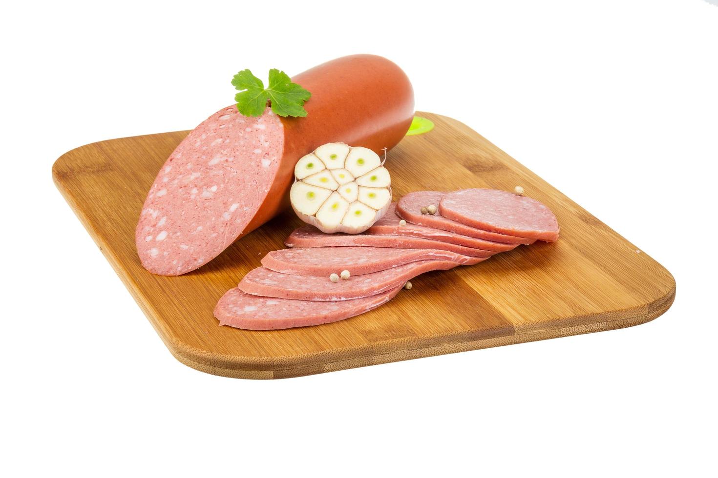 Sausages on wooden board and white background photo