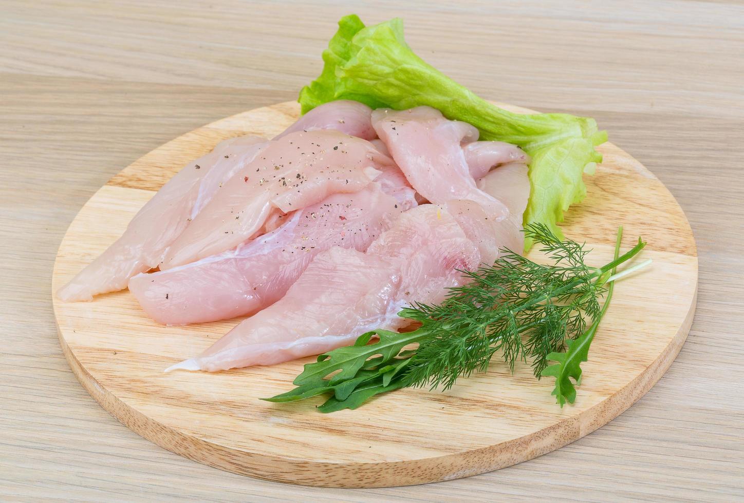 Raw chicken breast on wooden board and wooden background photo