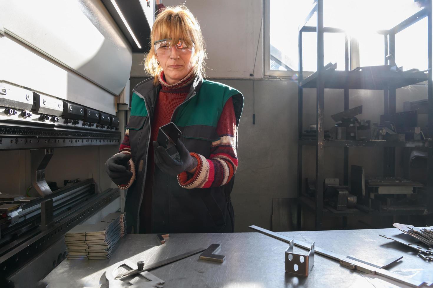 woman working in a modern factory and preparing materia for a CNC machine. photo