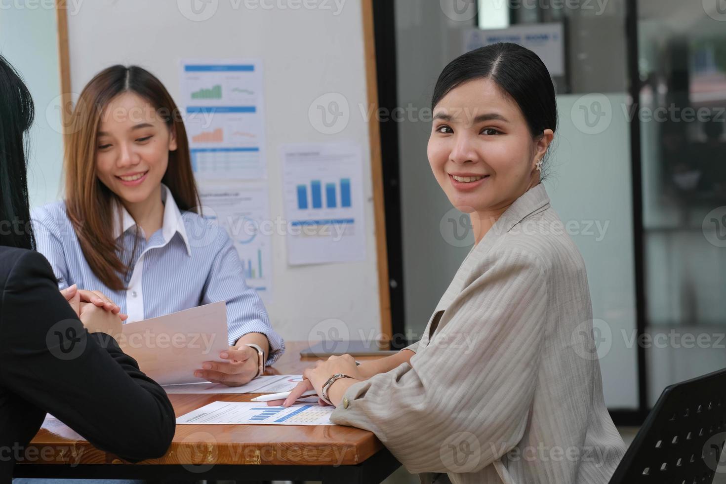 una joven asiática tiene una reunión de negocios con sus colegas de equipo en una sala de conferencias. foto