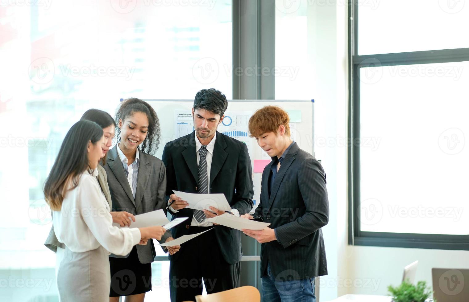 grupo de negocios asiáticos reunidos y discutiendo con un nuevo proyecto de idea de inicio. gente de negocios creativa que planifica el análisis de la estrategia y la lluvia de ideas con el informe del documento en la oficina foto