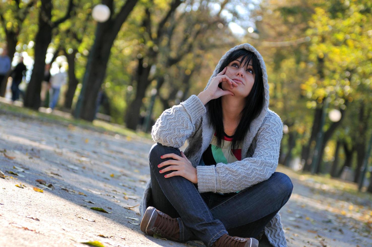 Cute young woman sitting outdoors in nature photo