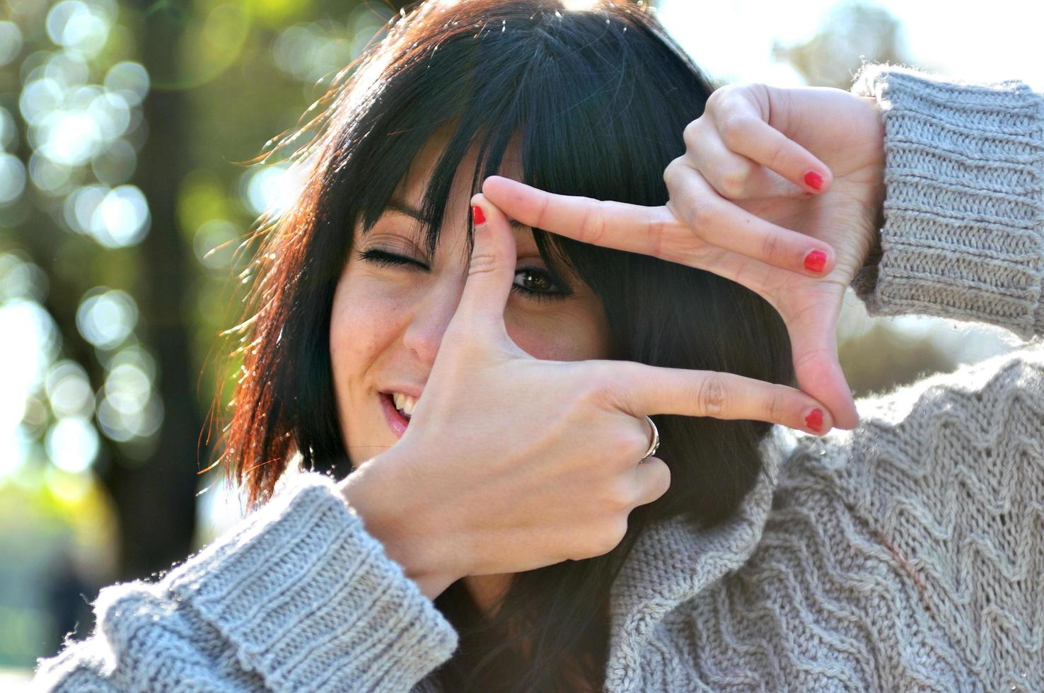 mujer joven que finge ver a través de una lente foto