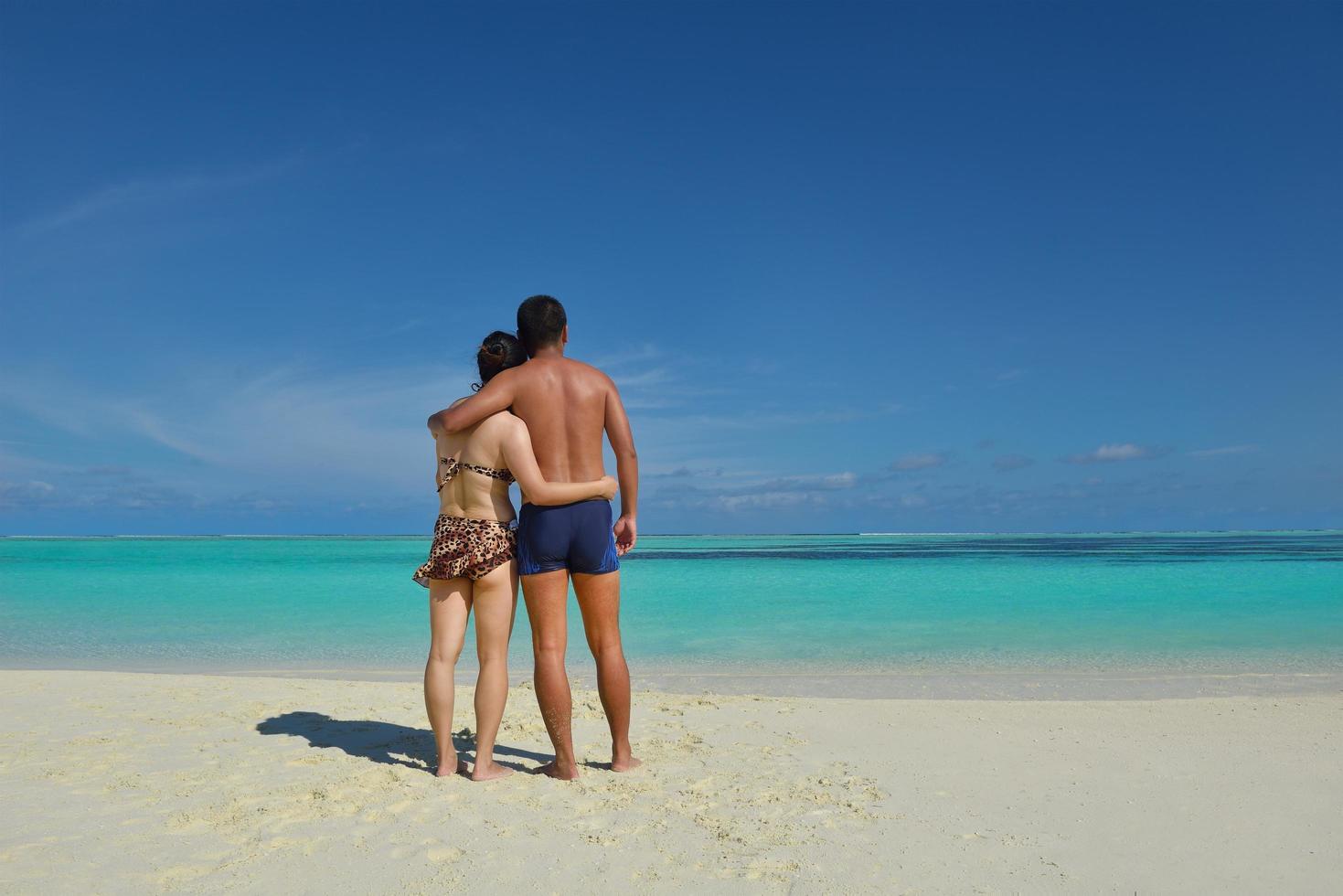 happy young  couple enjoying summer on beach photo